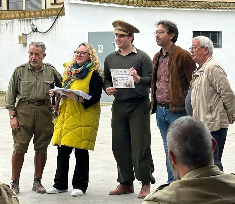 Miembros de la recreación posan con las autoridades del pueblo mientras se entrega un diploma durante la pausa del mediodía en Flix.