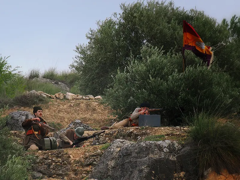 Recreadores de El Comité en posición defensiva entre olivos con bandera republicana durante la recreación de la batalla del Jarama en Morata de Tajuña 2026.