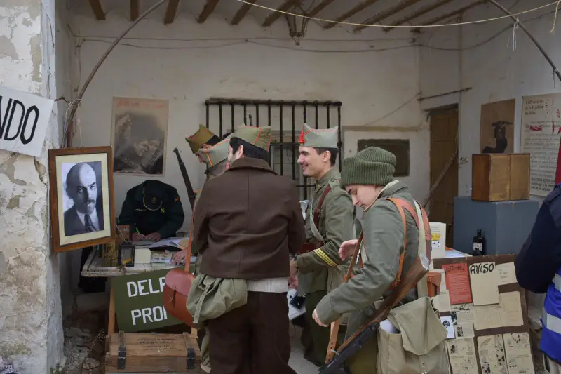 Recreadores con uniformes de la Guerra Civil española en una delegación de propaganda recreada con carteles y documentos de época
