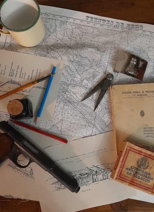 Mapa de Fuentes de Ebro, reglamento militar y material de escritura de época sobre una mesa de estudio de la Guerra Civil española